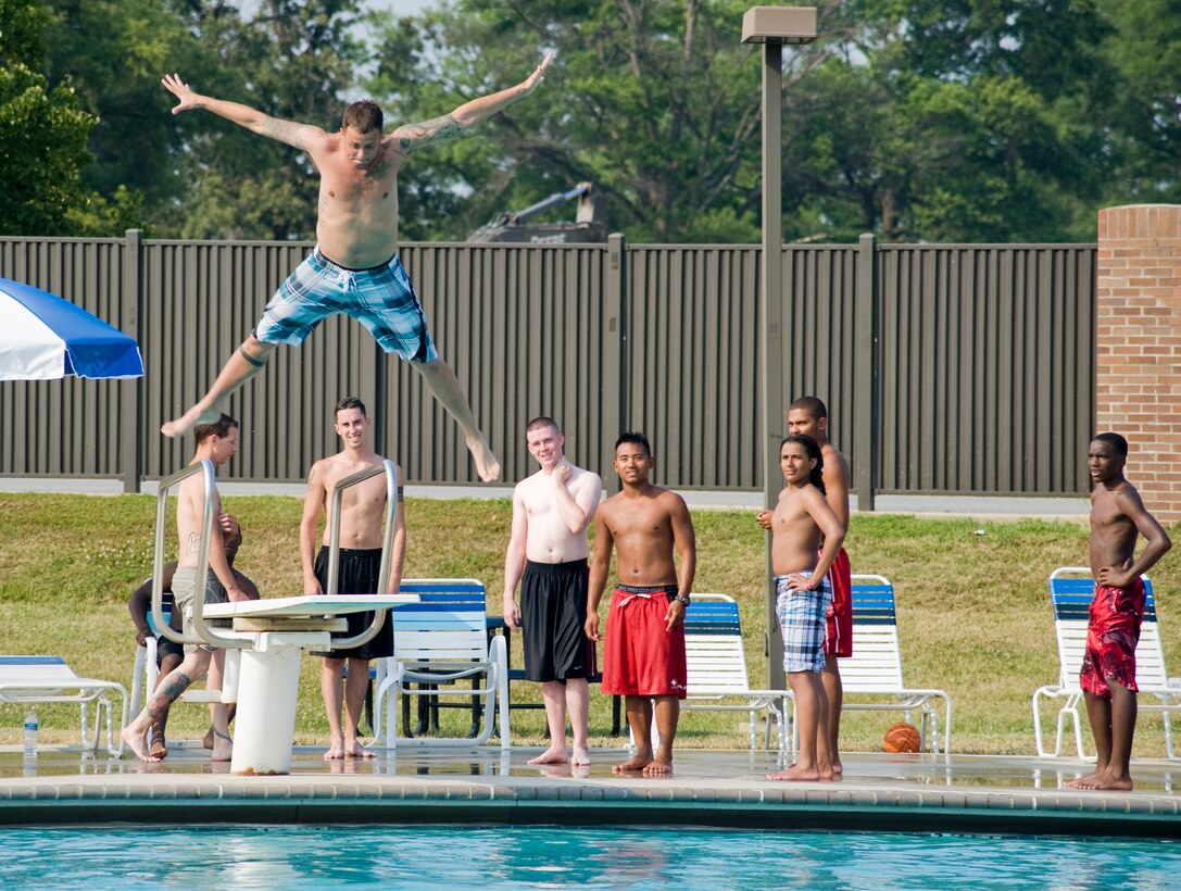Staff Sgt. Tony Tirado, 744th Communications Squadron radio frequency transmissions systems technician, prepares for a splash as he springs from a diving board at the base pool on June 21. The day's triple-digit temperatures brought large crowds to the base pool and area water parks. (Photo/Bobby Jones) 