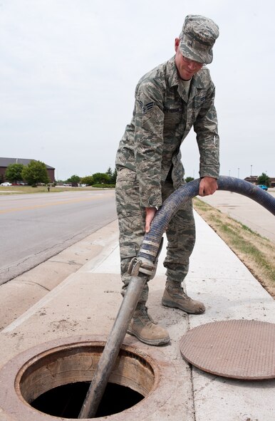 Senior Airman Joshua Peterson, 28th Civil Engineer Squadron water and fuels systems technician, vacuums debris out of a sewer line at Ellsworth Air Force Base, S.D., June 27, 2012. If the sewers are not cleaned regularly, debris can build up and cause the drain to overflow. (U.S. Air Force photo by Airman 1st Class Alystria Maurer/Released)
