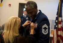 Retired U.S. Air Force Chief Master Sgt. John Hampton, Air Combat Command security forces manager, receives his retirement pin from his wife Christina at Moody Air Force Base, Ga., June 27, 2012. Hampton served 29 years on active duty and has been stationed at 15 bases. (U.S. Air Force photo by Airman 1st Class Paul Francis/Released)
