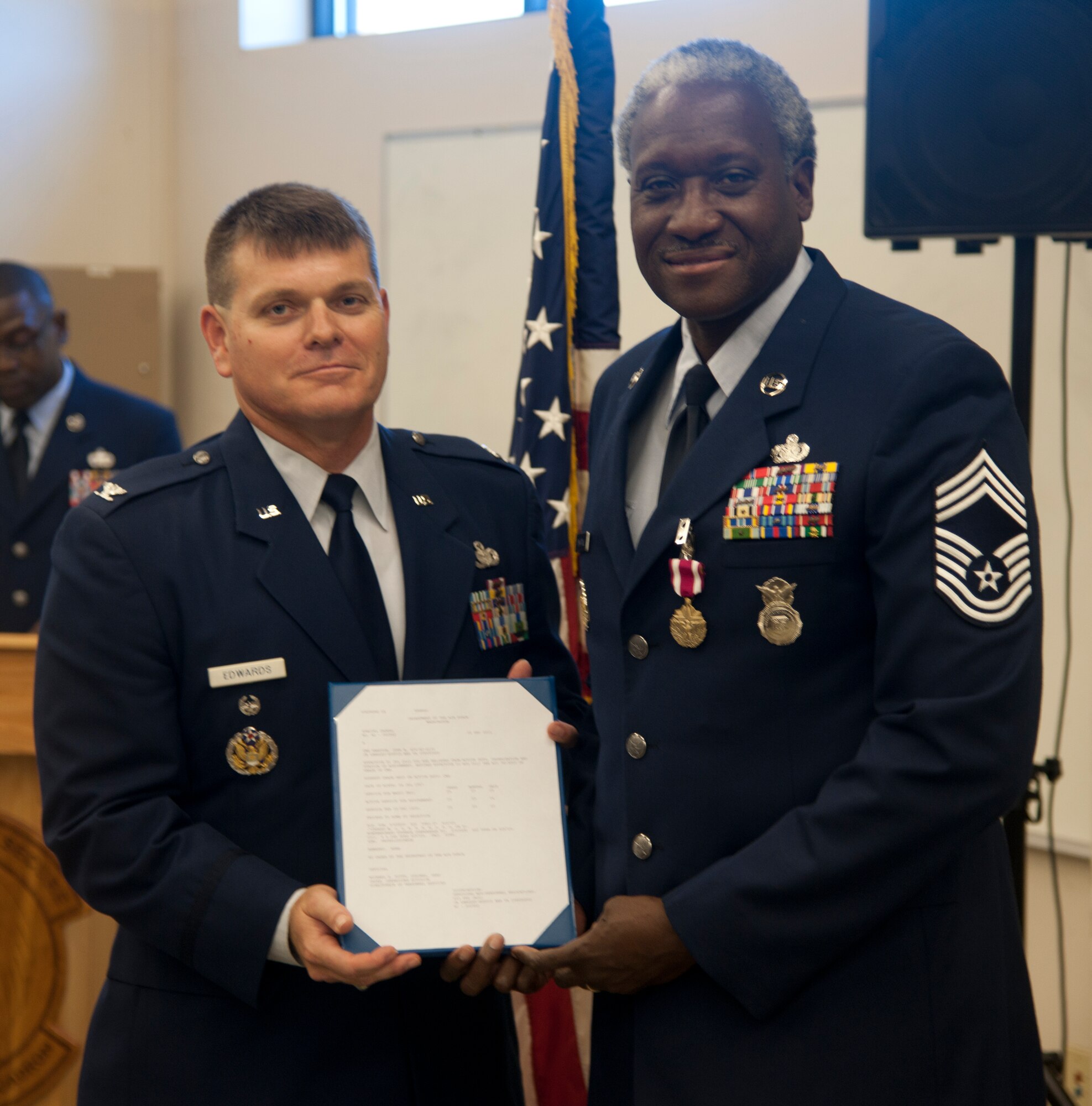 Retired U.S. Air Force Chief Master Sgt. John Hampton, Air Combat Command security forces manager,   receives his retirement certificate from Col. James Edwards, Chief Nuclear Security Operation, Pentagon , June 27, 2012, at Moody Air Force Base, Ga. Edwards reflected on Hampton’s career and how he influenced many Airmen over the years. (U.S. Air Force photo by Airman 1st Class Paul Francis/Released)
