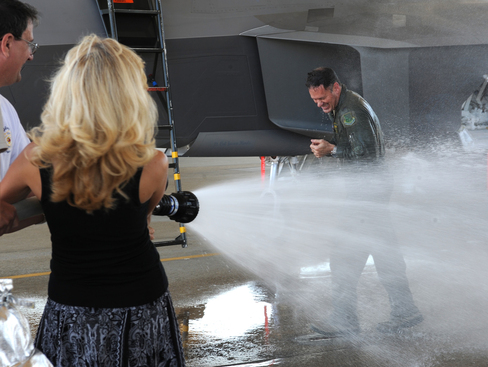 Leslie Boutwell, wife of U.S. Air Force Col. Richard Boutwell, 1st Operations Group commander, soaks her husband with water after his final flight at Langley Air Force Base, Va., June 27, 2012. The “fini” flight is an Air Force tradition which can be traced back to the Vietnam War. (U.S. Air Force photo by Airman 1st Class Teresa Cleveland/Released)