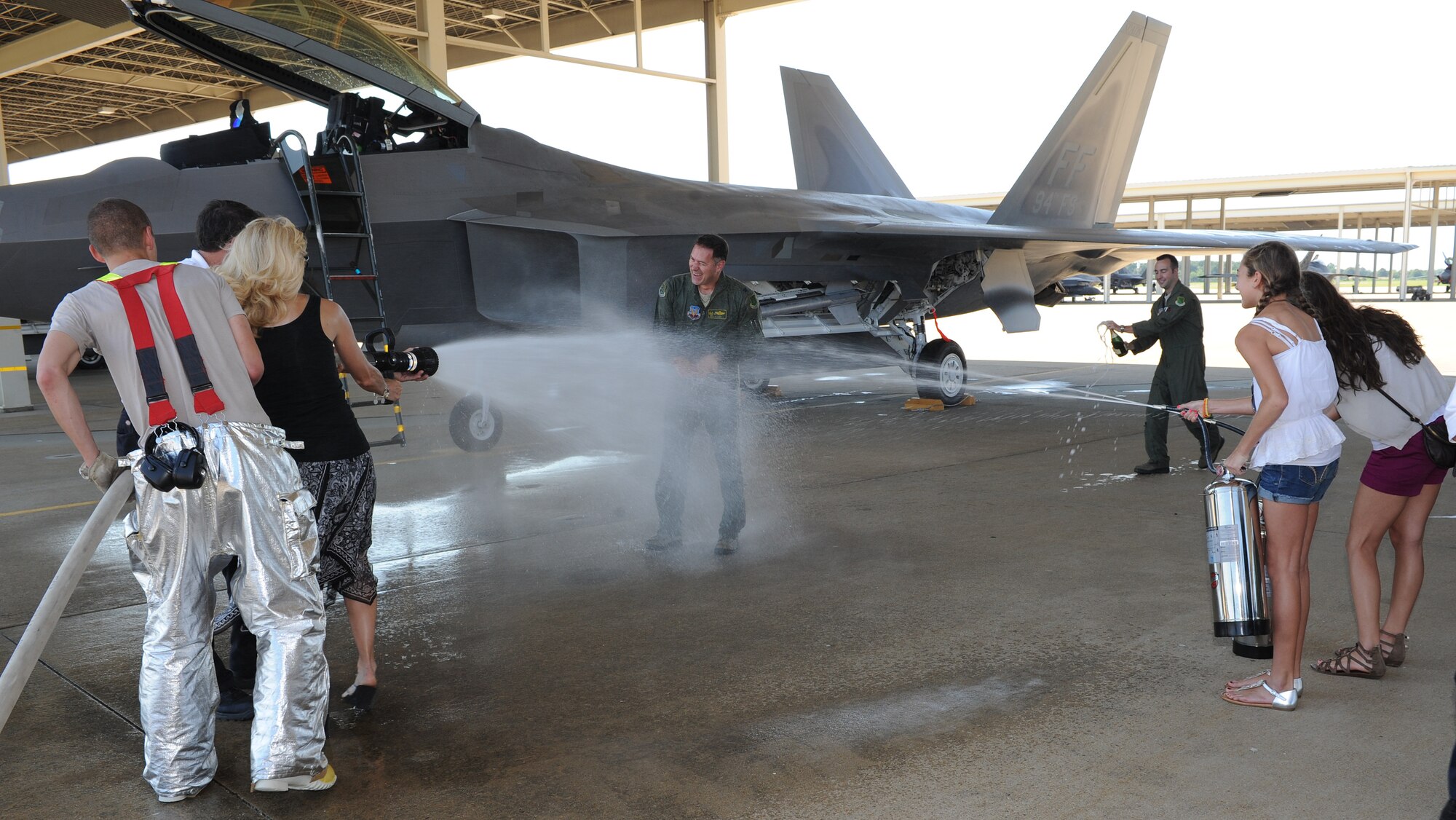 Family and friends of U.S. Air Force Col. Richard Boutwell, 1st Operations Group commander spray him with water hoses, fire extinguishers and champagne after his final flight at Langley Air Force Base, Va., June 27, 2012. After serving two years as the 1st OG commander, Boutwell will move on to a new assignment at Washington, D.C. (U.S. Air Force photo by Airman 1st Class Teresa Cleveland/Released)