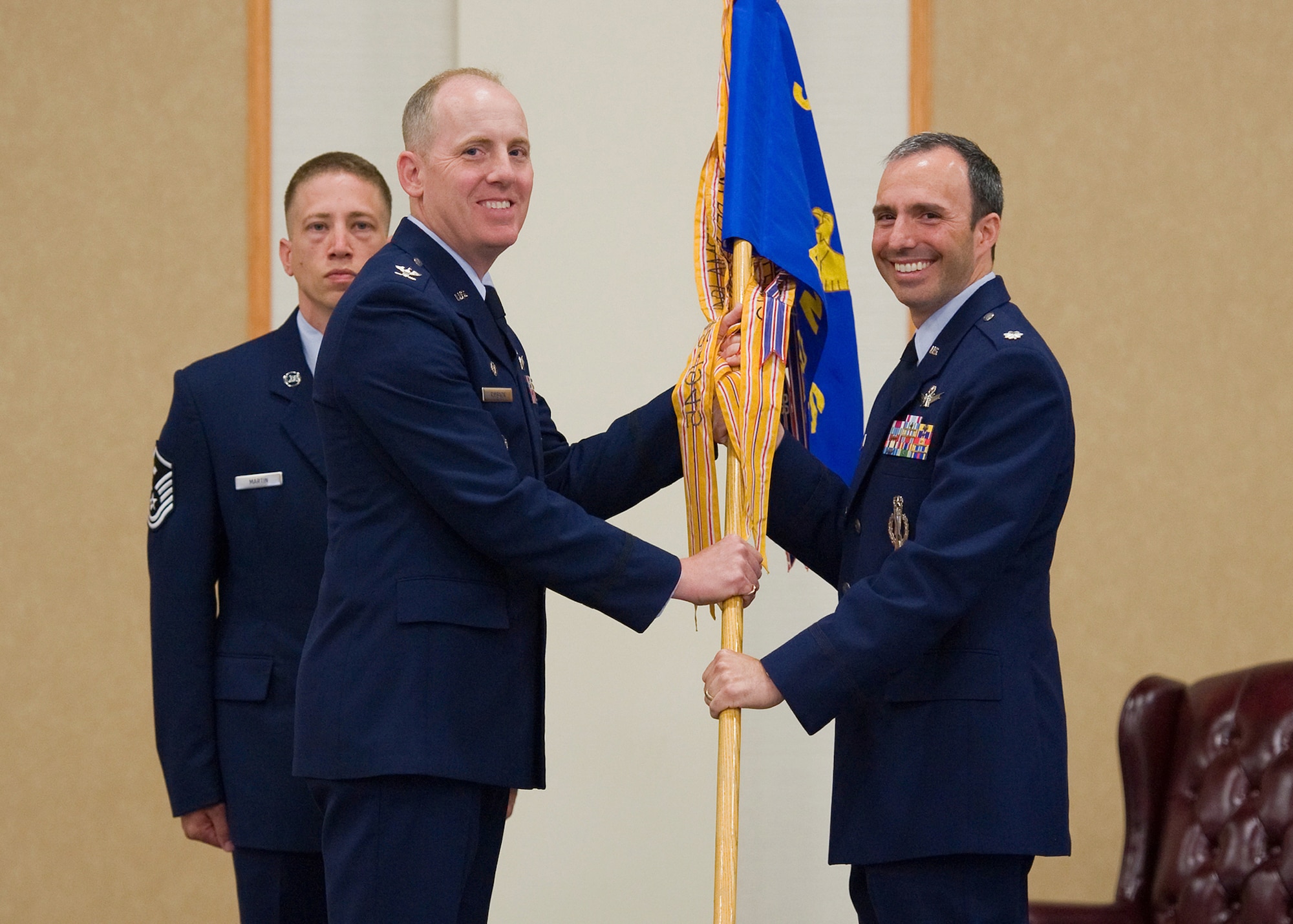 Lt. Col. Joseph Conti, right, accepts command of the 490th Missile Squadron from Col. Edward Rimback, 341st Operations Group commander June 25 at the Grizzly Bend. Master Sgt. Jeremiah Martin, 341st OG first sergeant, background, looks on. (U.S. Air Force photo/Beau Wade)