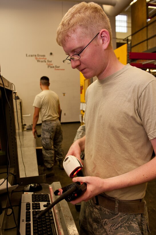Airman 1st Class Keith Bonbernewitz, 28th Aircraft Maintenance Squadron support section technician, scans a handheld radio during the process of checking it out to an Airman in the maintenance support section on Ellsworth Air Force Base, S.D., June 26, 2012. Airmen use a scanner to access a database of parts and customer identification numbers to increase efficiency when returning and receiving equipment. (U.S. Air Force photo by Airman 1st Class Kate Thornton/Released)