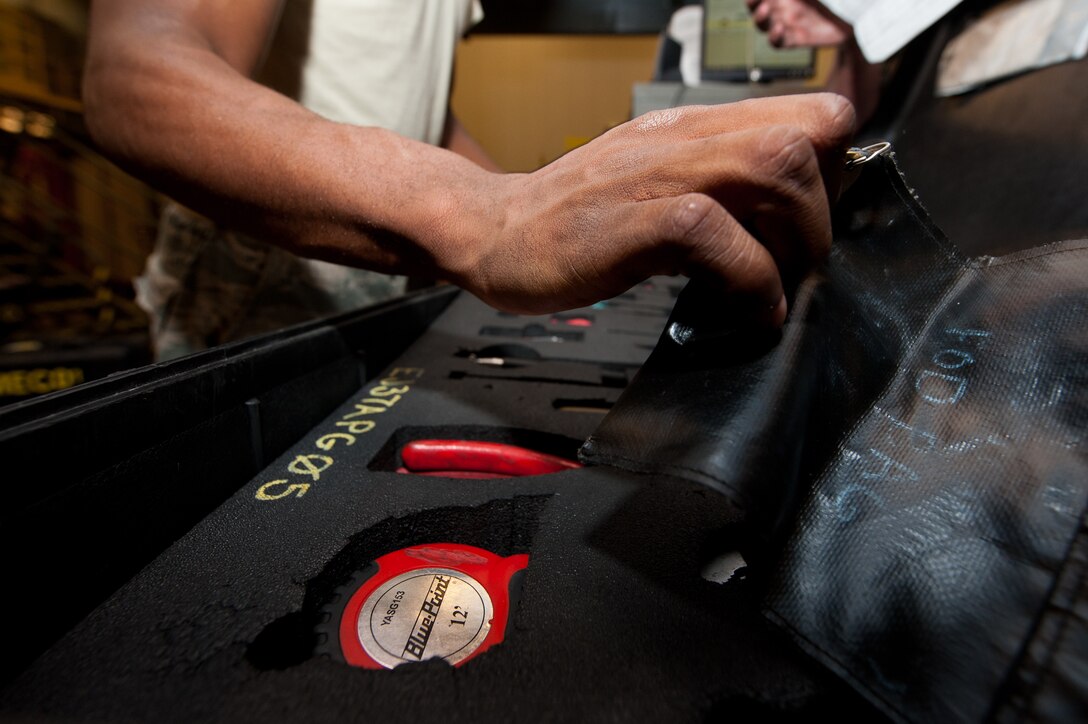 Airman 1st Class Deante Gibaldi, 28th Aircraft Maintenance Squadron crew chief, ensures that a foreign object and debris bag is empty while checking in tools during a shift change in the maintenance support section on Ellsworth Air Force Base, S.D., June 26, 2012. Support section specialists manage tools and equipment for 28th AMXS maintainers every day in the tool room in the base’s two bomb squadrons and all maintenance areas. (U.S. Air Force photo by Airman 1st Class Kate Thornton/Released)