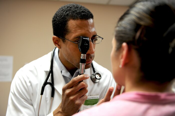 U.S. Air Force Maj. Eric Abbott, 99th Medical Group family medicine resident doctor, examines a patient's eyes at the Mike O' Callaghan Medical Center June 25, 2012, at Nellis Air Force Base, Nev. The residency program is a cornerstone of the former Mike O'Callaghan Federal Hospital's expansion to a Medical Center, enabling the addition of multiple medical care specialties to the hospital's services and bringing in medical research programs, all of which mean additional resources are available to patients. (U.S. Air Force photo by Staff Sgt. William P.Coleman)
