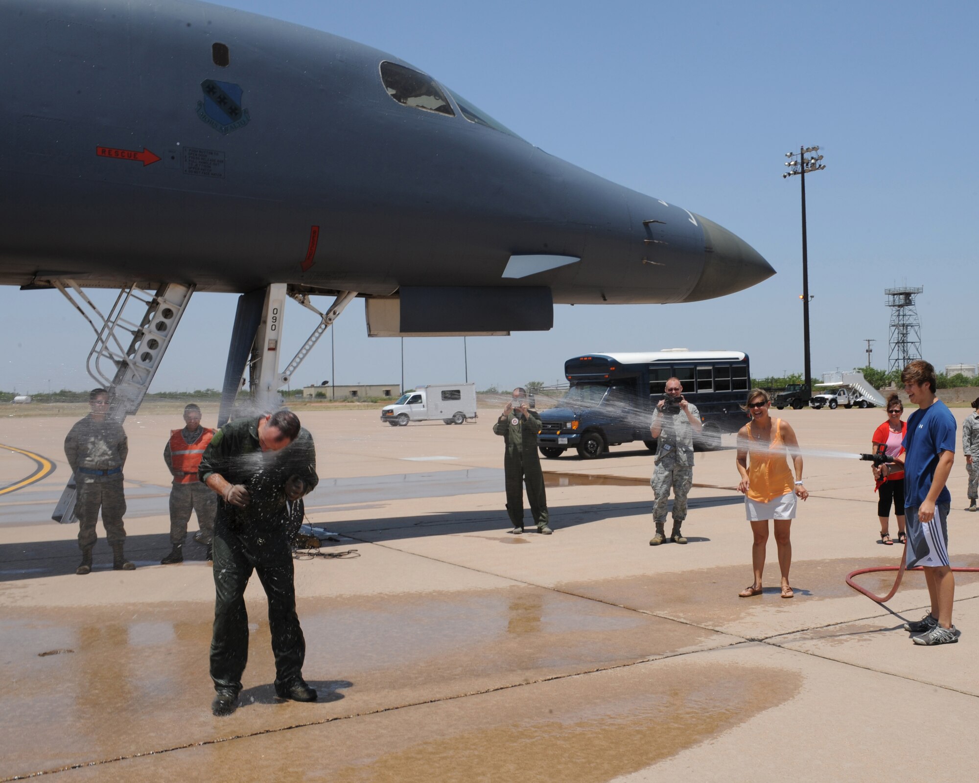 U.S. Air Force Col. David Béen, 7th Bomb Wing commander, is sprayed with a fire hose after his final flight June 26, 2012, at Dyess Air Force Base, Texas. Following a change of command ceremony July 3, Col. Béen will depart Dyess and will be assigned to the Pentagon in Washington, D.C. (U.S. Air Force photo illustration by Staff Sgt. Richard P. Ebensberger/ Released)