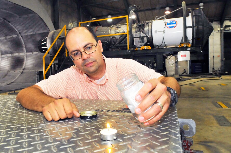 Juan Font, Hush House mechanical engineer, uses a sample of the Novec 1230 to demonstrate the effectiveness and advantages of the new fire suppression agent.  (U. S. Air Force photo/ Sue Sapp)