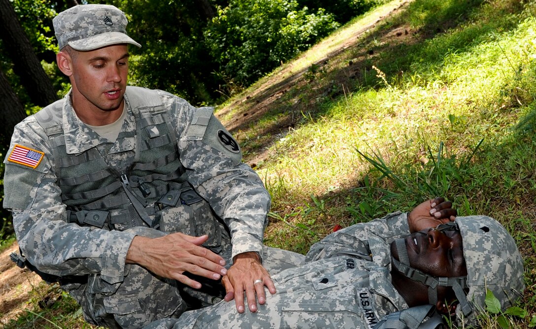 U.S. Army Staff Sgt. Jarod Moss, 95th Reserve Division drill sergeant, treats a soldier for wounds after finding out he was wounded during an exercise scenario being conducted, June 27, 2012, as part of the annual Drill Sergeant of the Year competition, hosted by Initial Military Training, U.S. Army Training and Doctrine Command, at Fort Eustis, Va. The week long competition challenges the drill sergeants both mentally and physically. (U.S. Air Force photo by Senior Airman Wesley Farnsworth/Released)