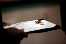 U.S. Air Force Chief Master Sgt. (ret.) Johnnie Yellock Sr. prepares to pass his son's Bronze Star Medal to Lt. Col. Chris Larkin, 23rd Special Tactics Squadron commander, during a ceremony for Staff Sgt. Johnnie Yellock Jr., 23 STS combat controller, June 26, 2012 at Hurlburt Field, Fla. Yellock received the Bronze Star for his deployment to Afghanistan in 2011 -- a deployment in which he was significantly wounded by an Improvised Explosive Device.(U.S. Air Force photo by Staff Sgt. David Salanitri) 