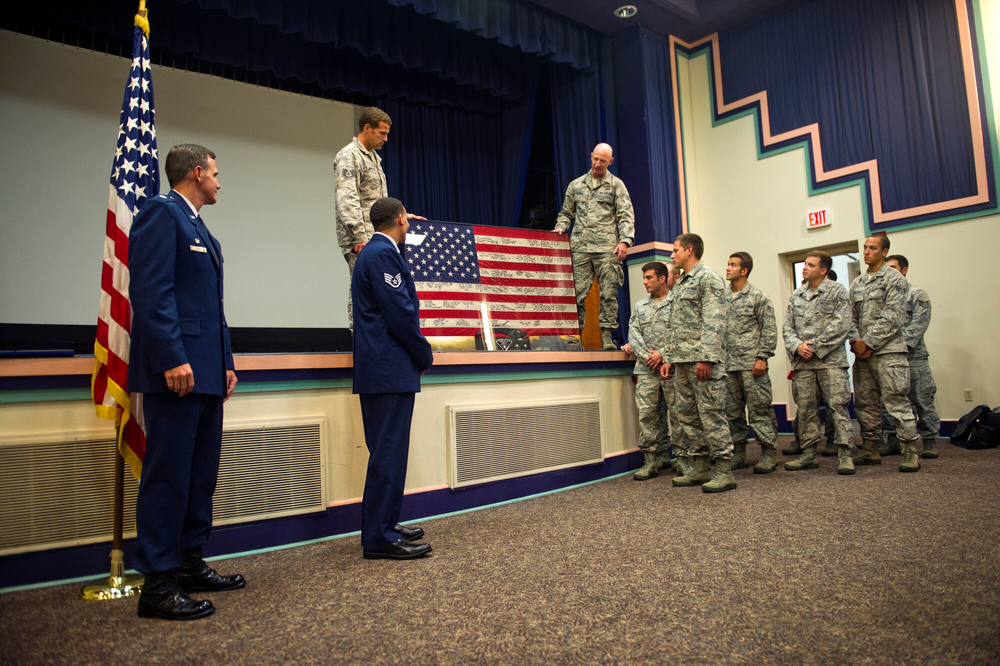 Deployed teammates of U.S. Air Force Staff Sgt. Johnnie Yellock Jr., a combat controller with the 23rd Special Tactics Squadron, present Yellock with an American flag during his Bronze Star Medal presentation ceremony, June 26, 2012 at Hurlburt Field, Fla. His teammates flew the flag in the months following an Improvised Explosive Device explosion that severely wounded Yellock. (U.S. Air Force photo by Staff Sgt. David Salanitri) 
