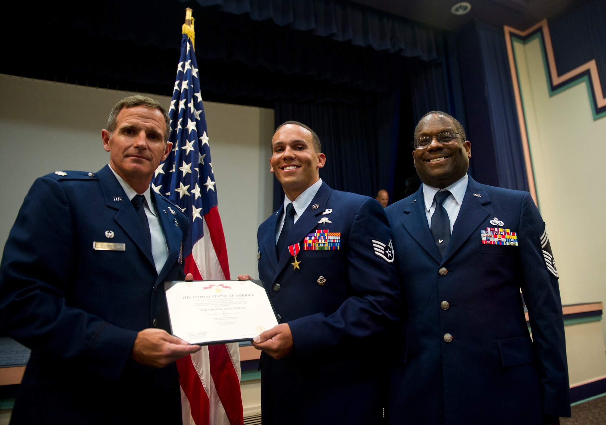From left, U.S. Air Force Lt. Col. Chris Larkin, 23rd Special Tactics Squadron commander, Staff Sergeant Johnnie Yellock Jr., a combat controller with the 23 STS, and Chief Master Sgt. (ret.) Johnnie Yellock Sr., pose for a picture during a Bronze Star Medal presentation, June 26, 2012 at Hurlburt Field, Fla.  Yellock received the Bronze Star for his deployment to Afghanistan in 2011 -- a deployment in which he was significantly wounded by an Improvised Explosive Device.  (U.S. Air Force photo by Staff Sgt. David Salanitri) 

