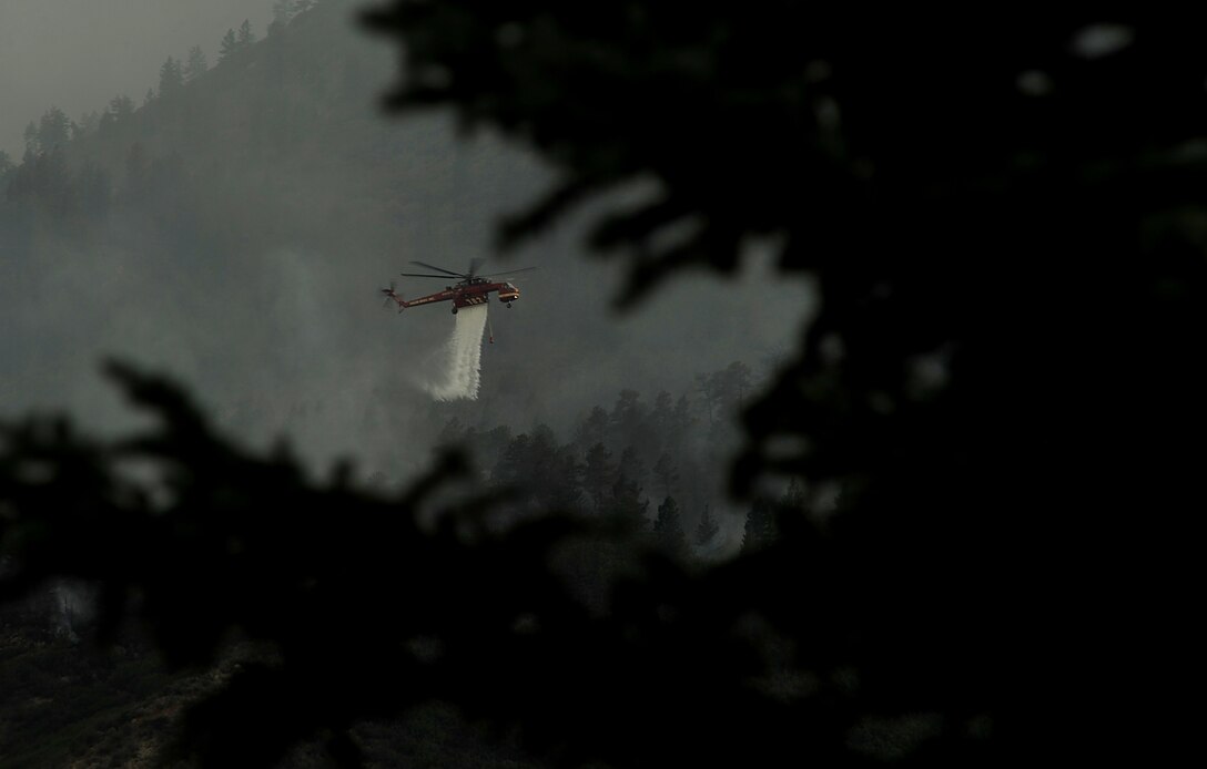A helicopter drops water on the fire as firefighters continued to battle the blaze that burned into the evening hours in Waldo Canyon on the U.S. Air Force Academy June 27, 2012. (U.S. Air Force Photo by: Master Sgt. Jeremy Lock)