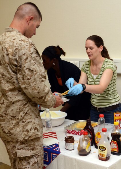 U.S. Air Force Senior Airman Rebecca Purshun, 175th Force Support Squadron, Maryland Air National Guard, serves pancakes to wounded military members at the Contingency Aeromedical Staging Facility, Ramstein Air Base, Germany, June 22, 2012.  Purshun volunteered with the USO on her day off during annual training in Germany. (National Guard photo by U.S. Air Force Staff Sgt. Benjamin Hughes)