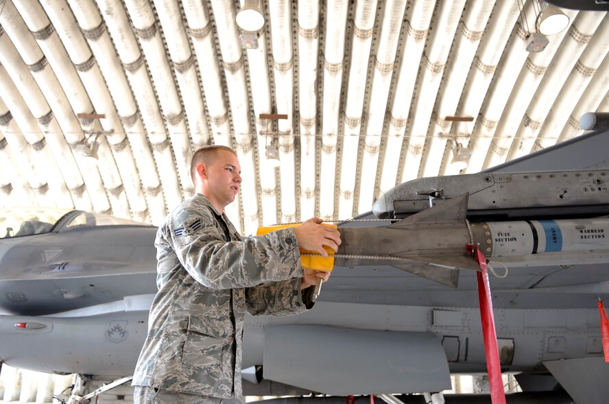 Senior Airman Ryan Rush, 80th Aircraft Maintenance Unit weapons load team member, makes sure all pieces on this F-16 Fighting Falcon are mission-ready June 23, 2012, at Kunsan Air Base, Republic of Korea. The 8th Maintenance Squadron prepared 16 aircraft which participated in joint naval operations to enhance interoperability with our allies and operational proficiency. (U.S. Air Force photo/Senior Airman Brigitte N. Brantley)