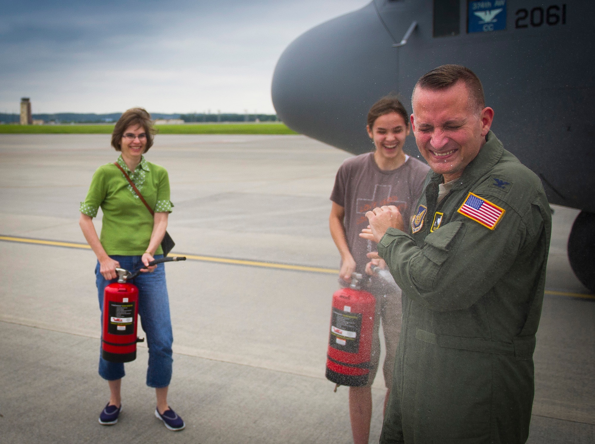 YOKOTA AIR BASE, Japan -- Col. Bill Knight, 374th Airlift Wing commander, gets sprayed by his wife, Susan, and daughter, Melissa, after completing his "fini-flight" at Yokota Air Base, Japan, June 25, 2012. After his change of command on June 29, Knight is relocating to the 11th Air Wing, Joint Base Andrews, Md. (U.S. Air Force photo by Staff Sgt. Chad C. Strohmeyer)