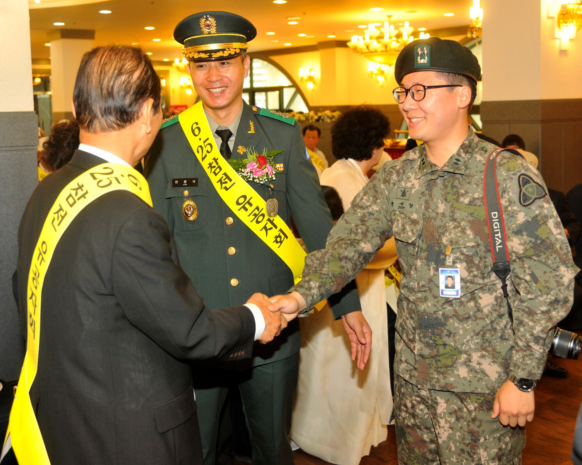 Dong-Shin Moon, left, shakes hands with the Republic of Korea Air Force photographer who documented the Korea War memorial ceremony in Gunsan City, Republic of Korea, June 25, 2012. More than 60 years ago, the United States and South Korea began fighting against North Korea and continue to remain allies. (U.S. Air Force photo/Senior Airman Marcus Morris)