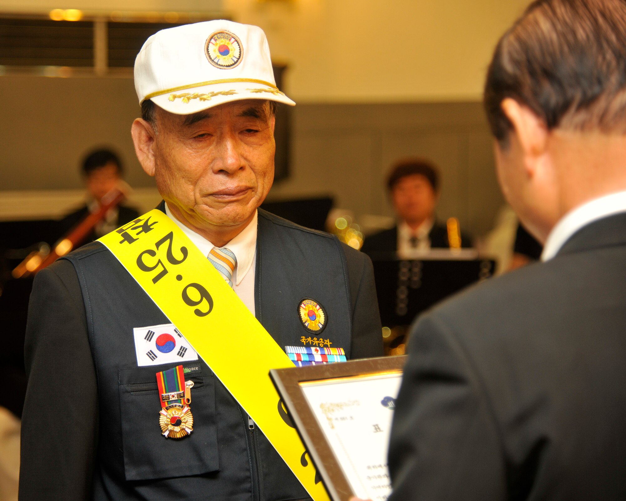 Jung-Gu Yi, left, receives a certificate of appreciation from Mayor of Gunsan City Dong-Shin Moon in Gunsan City, Republic of Korea, June 25, 2012. The certificate was for Yi’s dedicated time fighting during the Korean War. (U.S. Air Force photo/Senior Airman Marcus Morris)