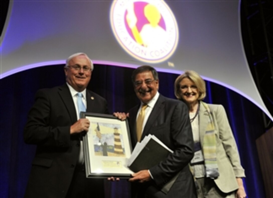Secretary of Defense Leon E. Panetta, center, is presented with a painting by President and CEO of the Military Child Education Coalition Mary Keller, right, and Bill Harrison, left, at the Military Child Education Coalition convention held at the Gaylord Texan in Grapevine, Texas, on June 27, 2012.  Panetta earlier delivered the keynote address to the convention audience.  