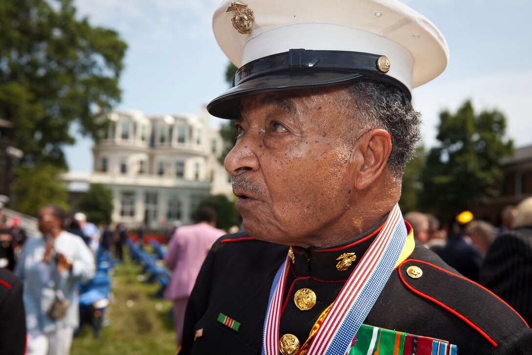 Retired Master Gunnery Sgt. Norman D. Epkin, a Montford Point Marine, speaks with guests after receiving a replica of Congressional Gold Medal at the conclusion of a presentation ceremony at the historic parade grounds of Marine Barracks Washington June 28. In 1942, President Roosevelt established a presidential directive giving African Americans an opportunity to be recruited ...into the Marine Corps. Between 1942 and 1949 approximately 20,000 African American Marines received basic training at the segregated Montford Point instead of the traditional boot camps of Parris Island, S.C. and San Diego, Calif. These men fought for their country with honor and valor that are hallmarks of the Corps, but they were not treated as equals to their white counterparts at the time. Gen. James F. Amos, commandant of the Marine Corps, set out to begin to right this wrong when he invited the Montford Point Marines to the Barracks Aug. 26, 2011 to be the guests of honor at a Friday Evening Parade, bringing their story to the national forefront and starting a chain of events that lead to this historic day.