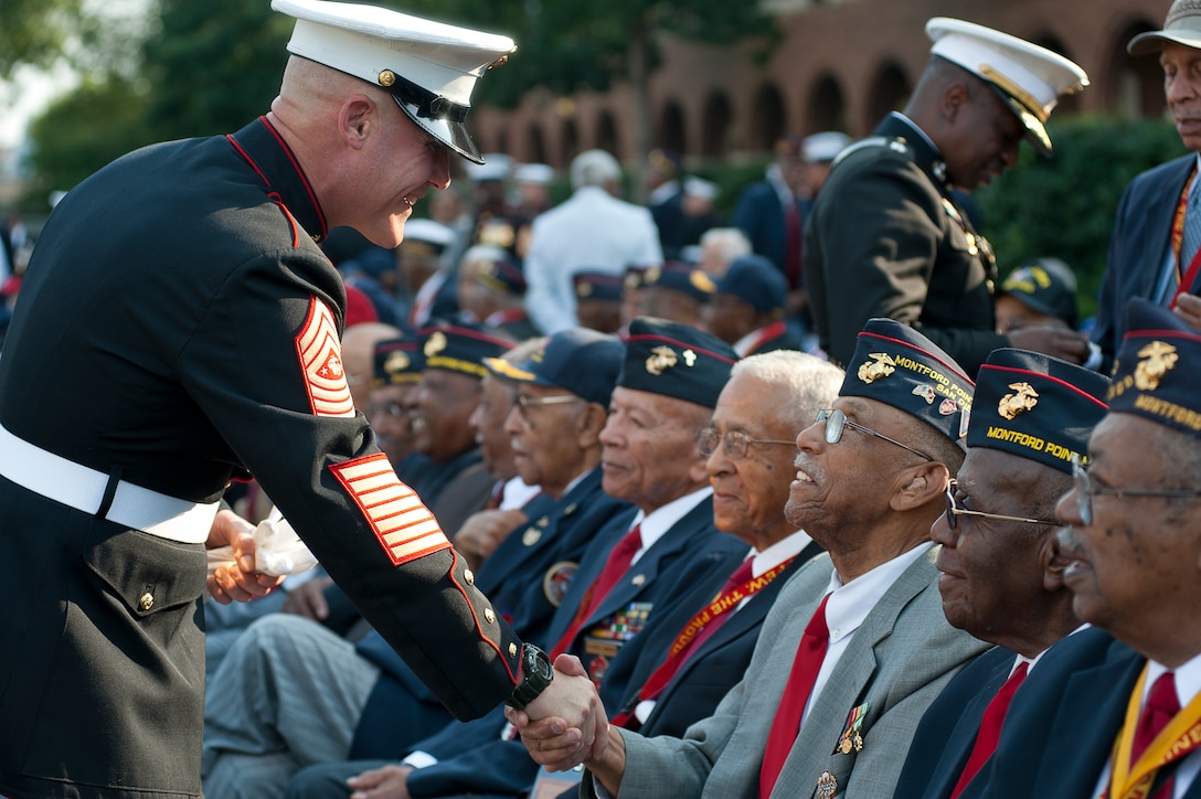 Sgt. Maj. of the Marine Corps Micheal Barrett, 17th sergeant major of the Marine Corps, personally thanks every Montford Point Marine in attendance before a Congressional Gold Medal presentation ceremony at the historic parade grounds of Marine Barracks Washington June 28. In 1942, President Roosevelt established a presidential directive giving African Americans an opportunity to be recruited into the Marine Corps. Between 1942 and 1949 approximately 20,000 African American Marines received basic training at the segregated Montford Point instead of the traditional boot camps of Parris Island, S.C. and San Diego, Calif. These men fought for their country with honor and valor that are hallmarks of the Corps, but they were not treated as equals to their white counterparts at the time. Gen. James F. Amos, commandant of the Marine Corps, set out to begin to right this wrong when he invited the Montford Point Marines to the Barracks Aug. 26, 2011 to be the guests of honor at a Friday Evening Parade, bringing their story to the national forefront and starting a chain of events that lead to this historic day.