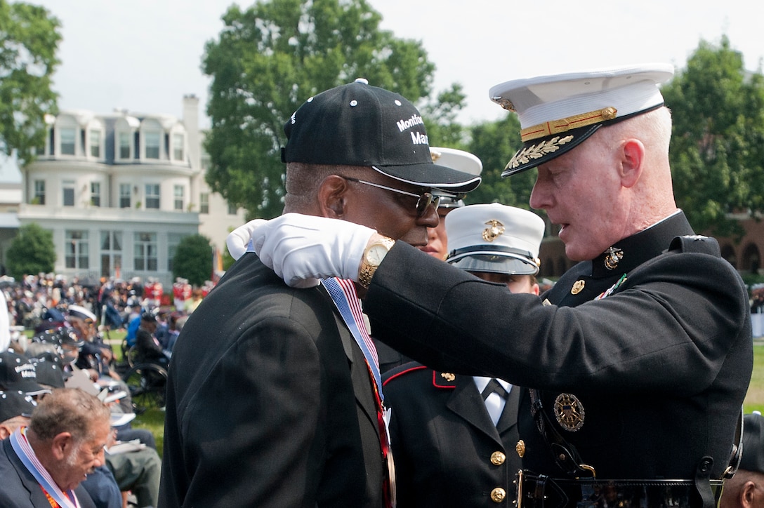 Lt. Gen. Richard T. Tryon, Marine Corps deputy commandant for plans, policies and operations, presents a Montford Point Marine with a bronze replica Congressional Gold Medal during a Congressional Gold Medal ceremony at Marine Barracks Washington June 28. In 1942, President Roosevelt established a presidential directive giving African Americans an opportunity to be recruited into the Marine Corps. Between 1942 and 1949 approximately 20,000 African American Marines received basic training at the segregated Montford Point instead of the traditional boot camps of Parris Island, S.C. and San Diego, Calif. These men fought for their country with honor and valor that are hallmarks of the Corps, but they were not treated as equals to their white counterparts at the time. Gen. James F. Amos, commandant of the Marine Corps, set out to begin to right this wrong when he invited the Montford Point Marines to the Barracks Aug. 26, 2011 to be the guests of honor at a Friday Evening Parade, bringing their story to the national forefront and starting a chain of events that lead to this historic day.