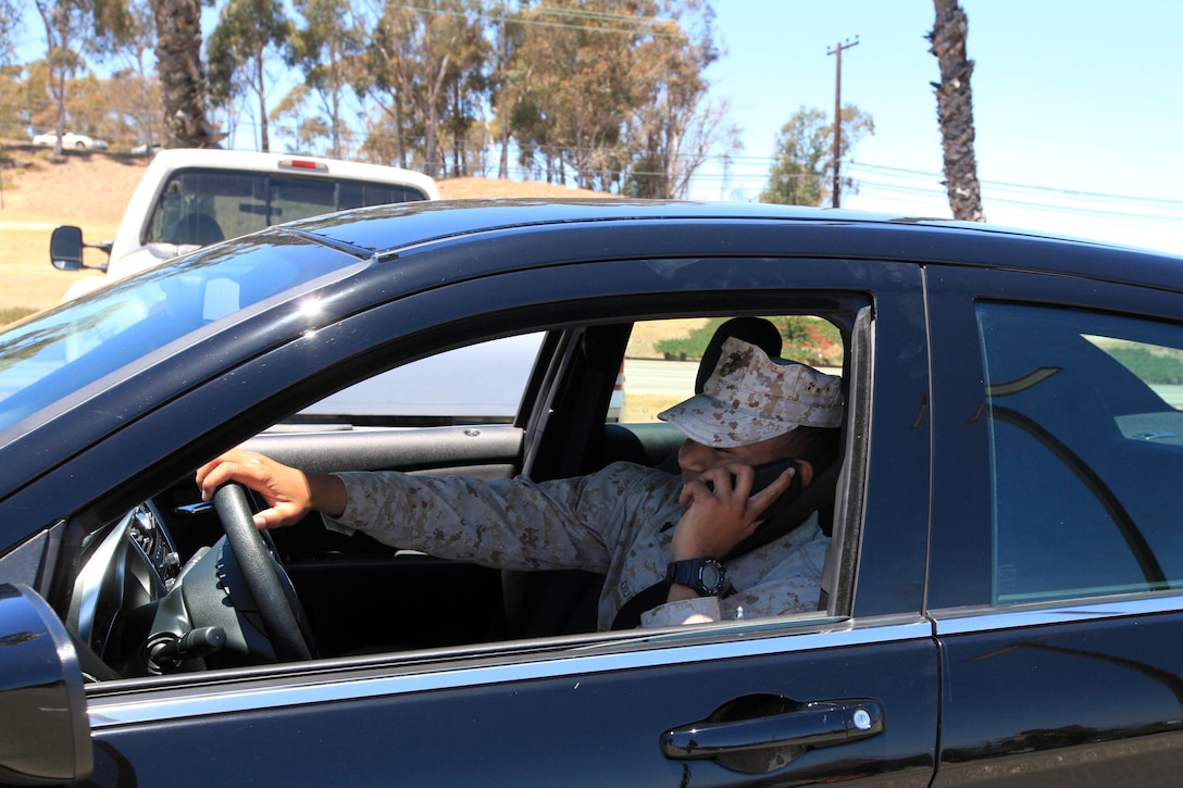 When using a cell phone while driving, drivers lose positive control of the vehicle because it takes their hands off the steering wheel. Drivers without a hands-free device who need to make or recieve a call should pull over to a safe spot and use their cell phone. (Photo illustration)