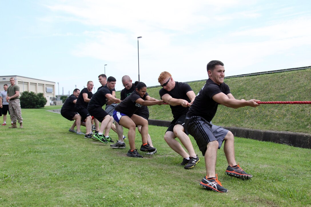 Marine Wing Support Squadron 171 Marines with airfield operations compete in the tug-of-war event during the MWSS-171 field meet held at the IronWorks Gym here June 29, 2012. The tug-of-war event required the participants to lay down with their feet across the rope and upon receiving the signal, to scramble to their feet and begin to pull the rope. This event gathered a large crowd to cheer for their respective teams.