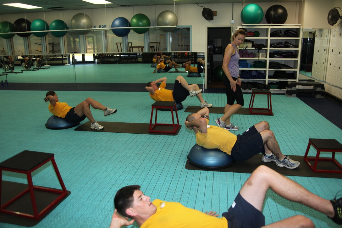 Ava A. Alexander, a Semper Fit instructor, instructs Sailors with the  aquatic survival training center on proper technique during their morning workout at the Fitness Connection, June 29. Semper Fit conducts unit physical training sessions throughout the week at multiple locations on the air station.