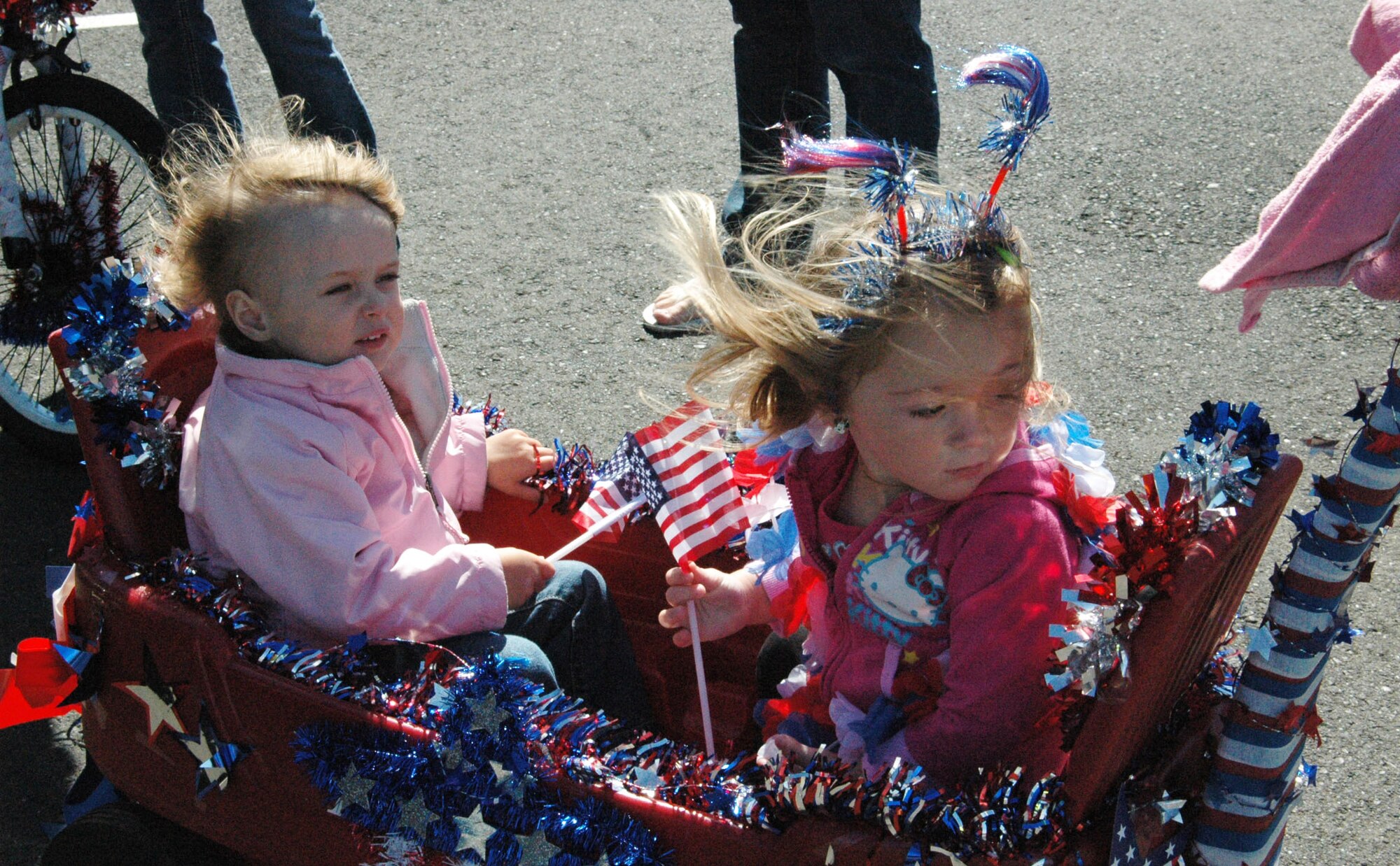 Shiloh Maple, left, sand Ava Sanders ride in their patriotically decorated wagon June 22, 2012 in the Balfour Beatty Communities parade at Travis Air Force Base, Calif. (U.S. Air Force photo/Tyler Grimes)