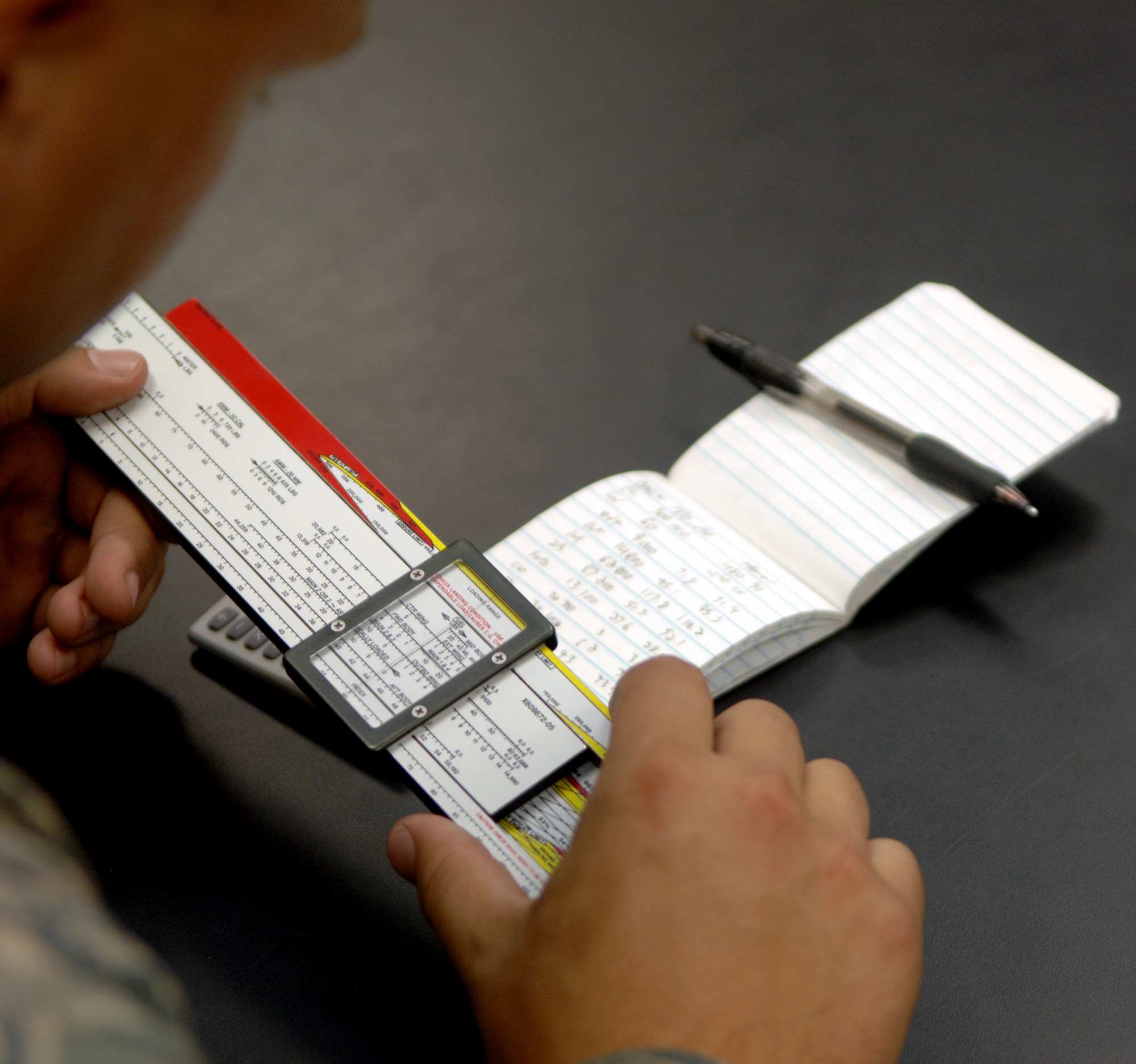 Airman 1st Class Travis Pratt, 2nd Maintenance Squadron Field Training Detachment 5 student, uses a slide rule and notes from his FTD class to calculate weights of different configurations of fuel, bombs and equipment at Barksdale Air Force Base, La., June 28. Pratt is one of many maintenance personnel from the flightline that go through the 372nd Training Squadron FTD 5 airframe power plant general class.  (U.S. Air Force photo/Staff Sgt. Jason McCasland)(RELEASED)