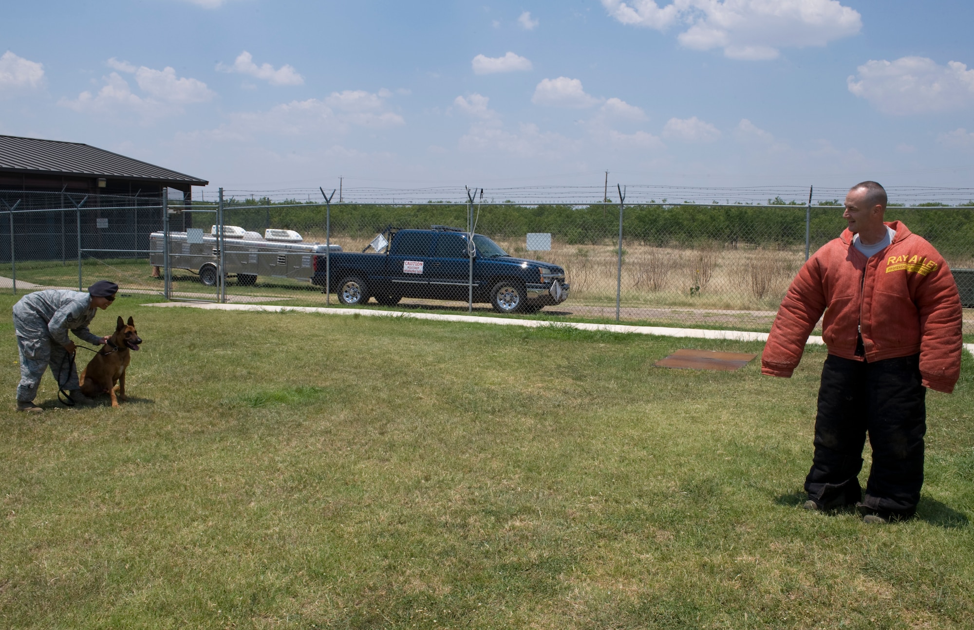 U.S. Air Force Staff Sgt. Patricia Eckles, 7th Security Forces Squadron, left, prepares to release her military working dog Dewey on Col. David Béen, 7th Bomb Wing commander, June 26, 2012, at Dyess Air Force Base, Texas. Béen received an opportunity to see and feel the capabilities of a military working dog first hand. MWDs are used on patrol, drug and explosive detection, as well as suspect apprehension. (U.S. Air Force photo by Staff Sgt. Richard P. Ebensberger/ Released)
