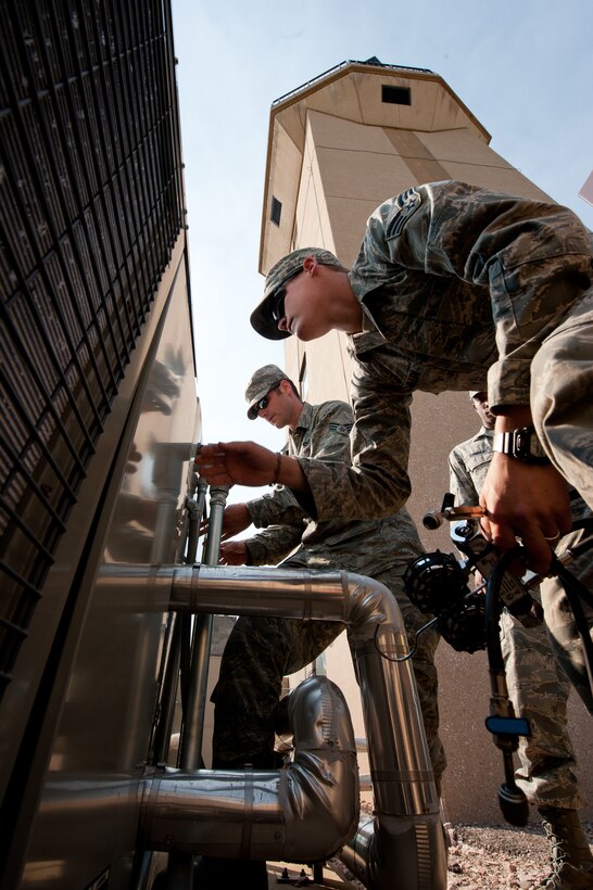Senior Airmen David McMillen (front) and Hugh Blacketor, 28th Civil Engineer Squadron heating, ventilation, and air conditioning technicians, inspect their completed work after adding refrigerant to a chiller during maintenance at the base air traffic control tower on Ellsworth Air Force Base, S.D., June 28, 2012. HVAC specialists are responsible for maintaining heating, ventilation and air conditioning systems in facilities on base. (U.S. Air Force photo by Airman 1st Class Kate Thornton/Released)