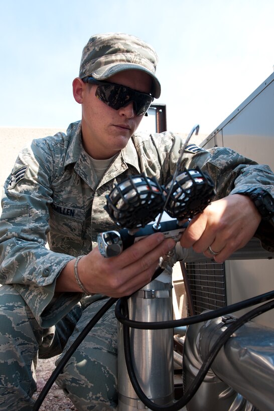 Senior Airman David McMillen, 28th Civil Engineer Squadron heating, ventilation, and air conditioning technician, monitors the amount of refrigerant entering a chiller during maintenance at the base air traffic control tower on Ellsworth Air Force Base, S.D., June 28, 2012. By adding refrigerant, the Airmen are preventing the chiller from possibly freezing up and costing thousands of dollars to replace. (U.S. Air Force photo by Airman 1st Class Kate Thornton/Released)