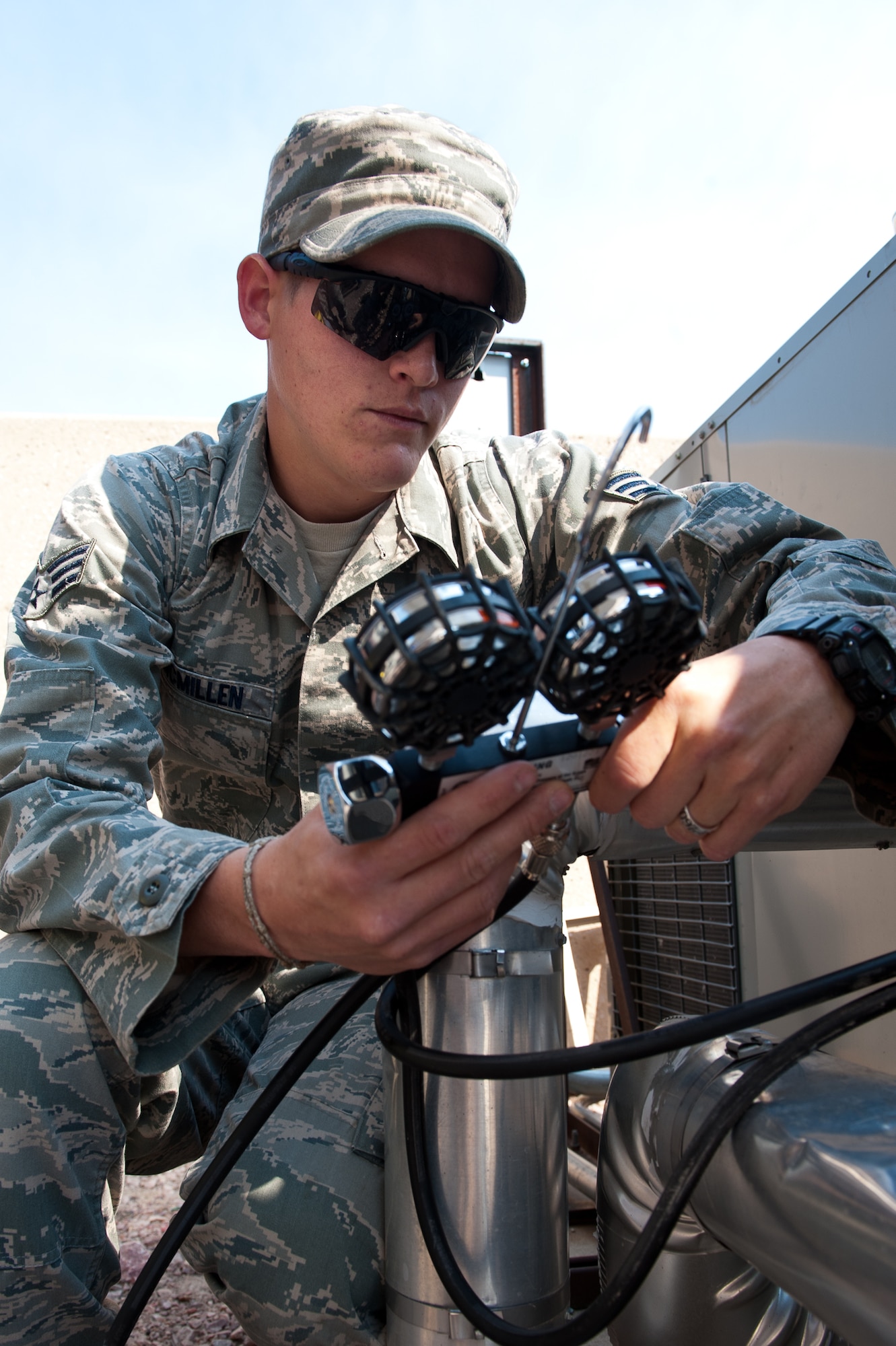 Senior Airman David McMillen, 28th Civil Engineer Squadron heating, ventilation, and air conditioning technician, monitors the amount of refrigerant entering a chiller during maintenance at the base air traffic control tower on Ellsworth Air Force Base, S.D., June 28, 2012. By adding refrigerant, the Airmen are preventing the chiller from possibly freezing up and costing thousands of dollars to replace. (U.S. Air Force photo by Airman 1st Class Kate Thornton/Released)