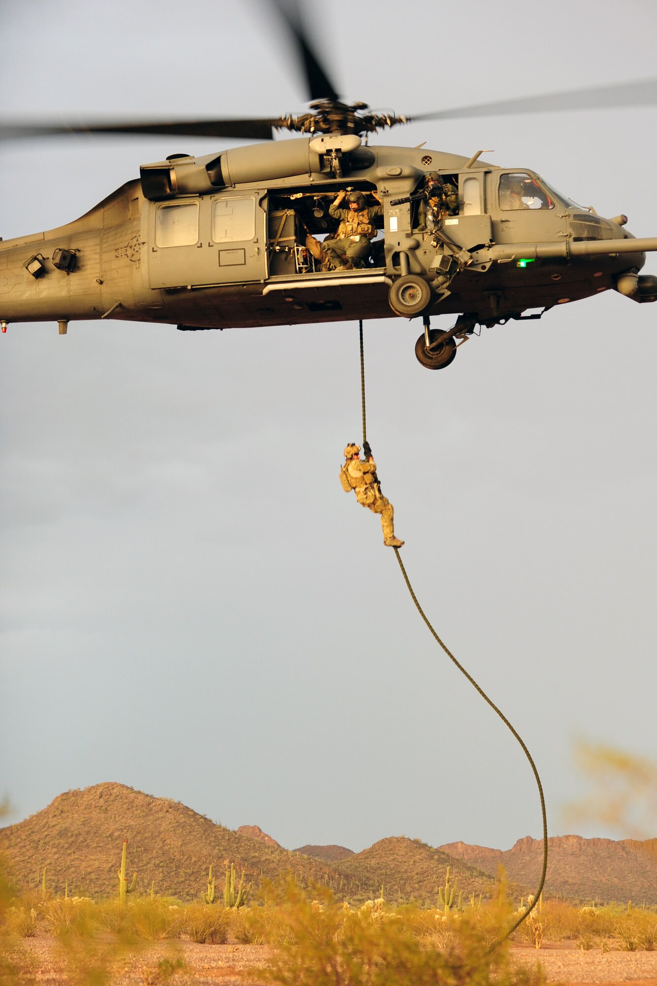A U.S. Air Force pararescueman from the 48th Rescue Squadron descends from an a HH-60 Pave Hawk during a training flight in Tucson, Ariz., June 27, 2012. The training is essential to keep pararescumen’s skills sharp. (U.S. Air Force photo by Airman 1st Class Camilla A Griffin/Released)