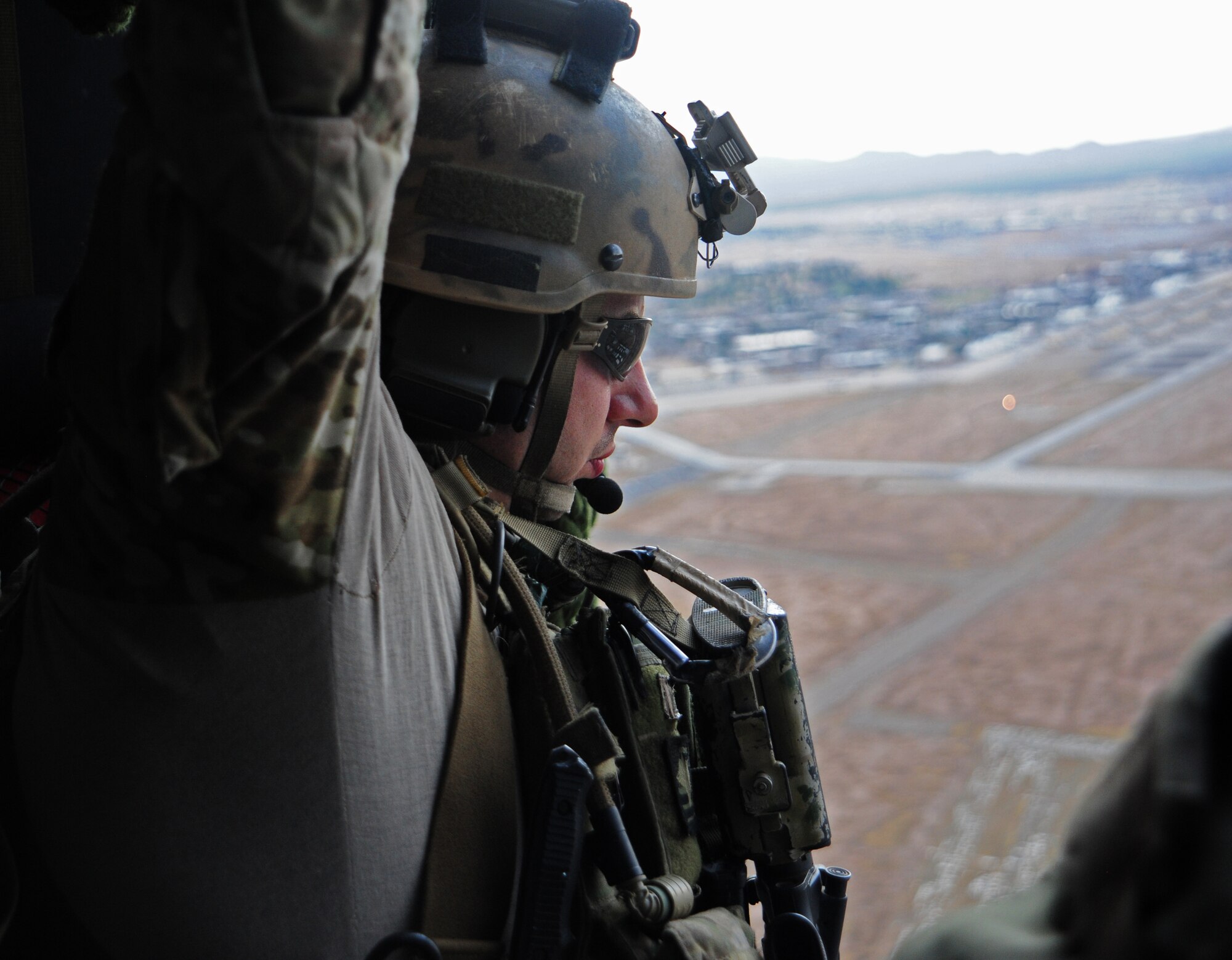 U.S. Air Force Staff Sgt. Sean Sylvia, 48th Rescue Squadron pararescueman, looks out of a HH-60 Pave Hawk during a training flight in Tucson, Ariz., June 27, 2012. The training is essential to keep pararescumen’s skills sharp. (U.S. Air Force photo by Airman 1st Class Camilla A Griffin/Released)