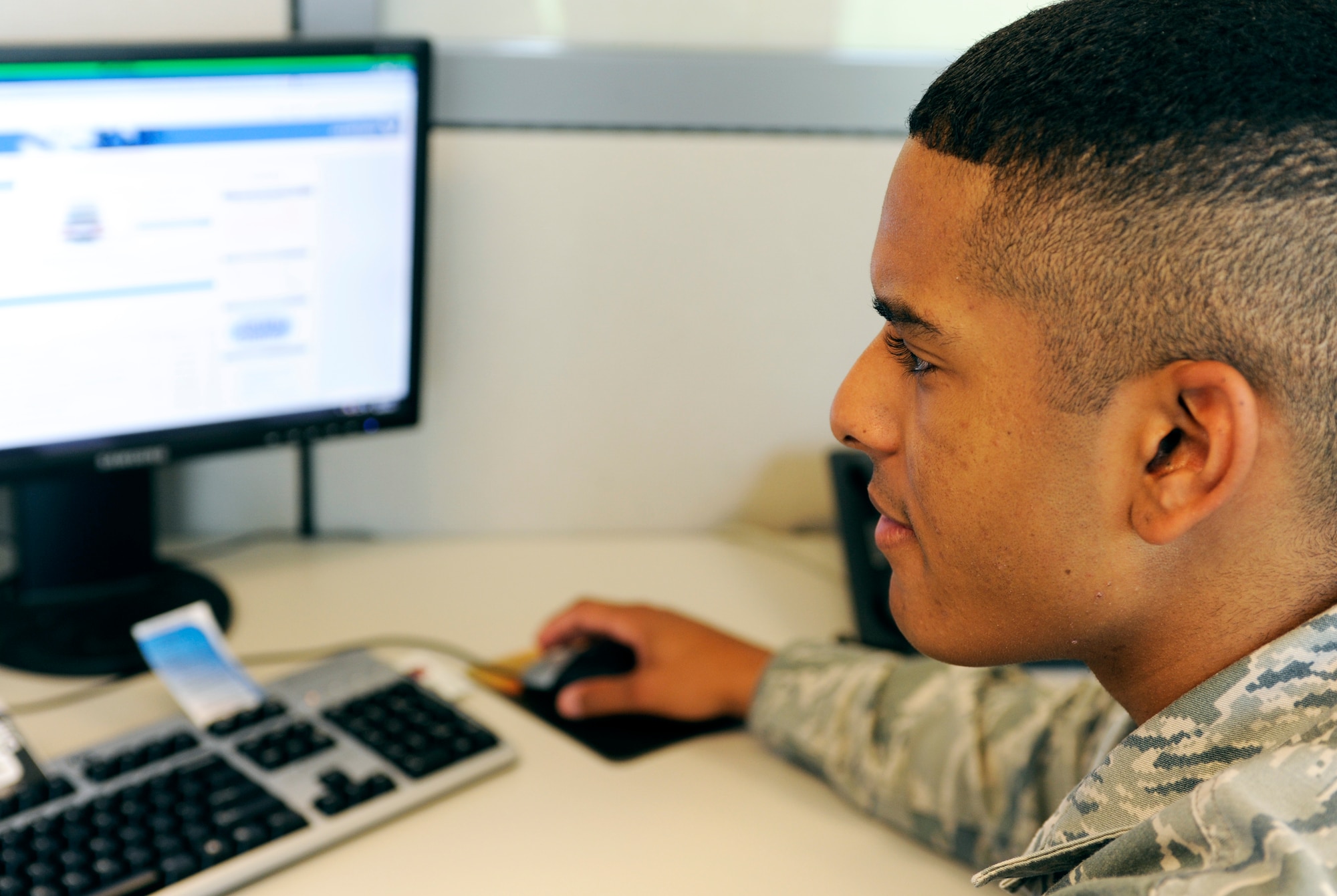 Airman 1st Class Robert Collins, 28th Communications Squadron cyber systems technician, reviews material at his desk in the new 28th CS customer service section located in Bldg. 2010 on Ellsworth Air Force Base, S.D., June 28, 2012. The 28th CS customer service section has moved from its previous location to the former Air Force Financial Services Center administration building across the street from the base dining facility. (U.S. Air Force photo by Airman Ashley J. Cass/Released)
