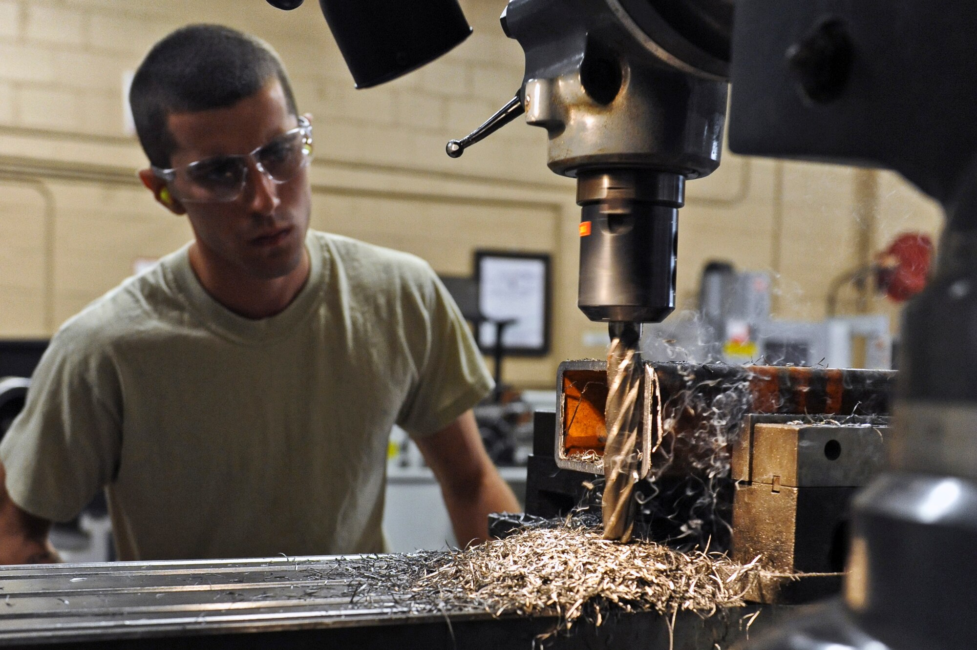 Airman 1st Class Cameron Arruda, 2nd Maintenance Squadron, mills a B-52H Stratofortress pylon test fixture in the 2 MXS fabrication hangar on Barksdale Air Force Base, La., June 29. The milling machine makes precision cuts as small as 0.001 of an inch. Once the process is complete, the leftover metal is collected and recycled. (U.S. Air Force photo/Airman 1st Class Micaiah Anthony)(RELEASED)