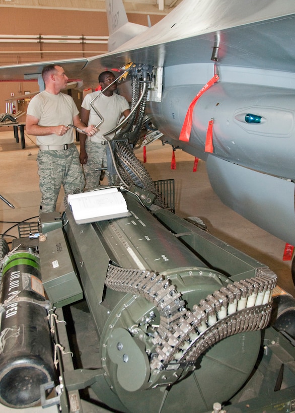 Airman 1st Class Kyle Ranville and Airman 1st Class Travis Gaskins-Smith of the 363 Training Squadron practice loading 20mm ammunition into the gun of an F-16. The airmen are using a Universal Ammunition Loading Set (UALS) to load the ammunition on June 23, 2011. (U.S. Air Force photo/Frank H. Carter)