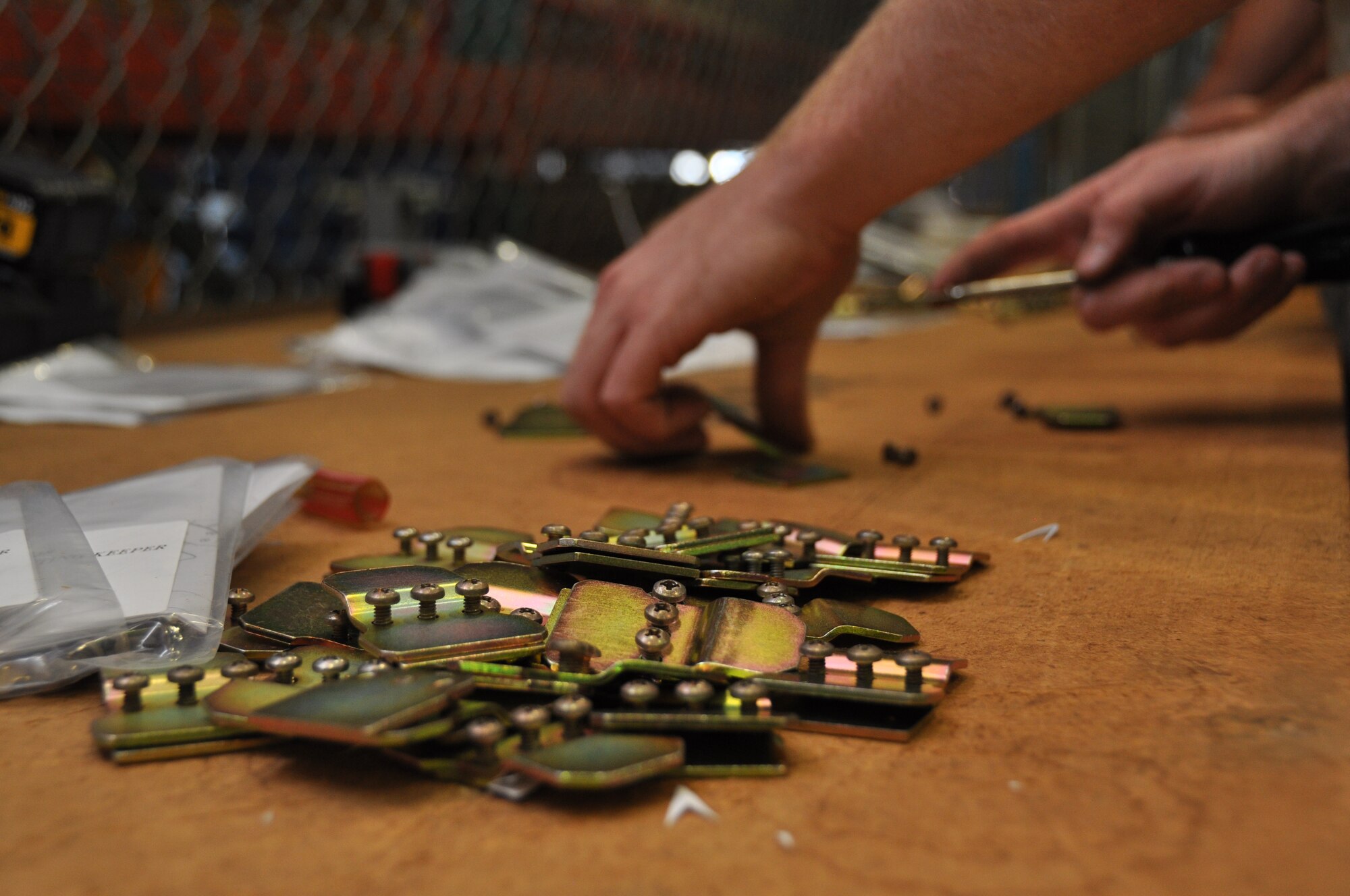 Airman 1st Class Daniel Hall, 60th Aerial Port Squadron, works on assembling the repair kits June 12 at the Boeing site in Long Beach, Calif., and places completed repair kits in a pile to be installed on the devices. (U.S. Air Force photo/Airman 1st Class Madelyn Ottem)