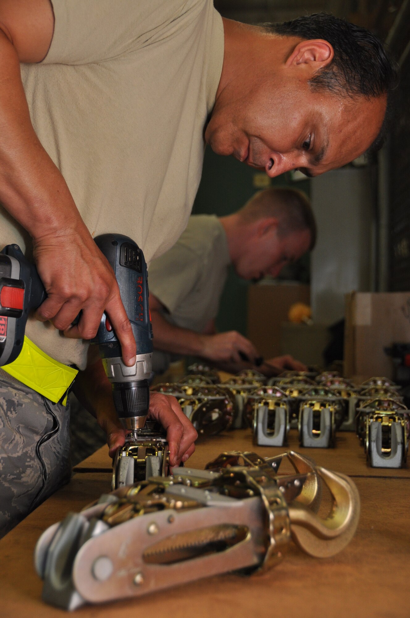 Chief Master Sgt. Enrique Flores, 60th Aerial Port Squadron traffic manager, drills the completed repair kits onto the faulty devices, rendering them serviceable June 12 at the Boeing site in Long Beach, Calif. The Travis Aerial Port Squadron team fixed more than 500 of the faulty devices in one day. (U.S. Air Force photo/Airman 1st Class Madelyn Ottem)
