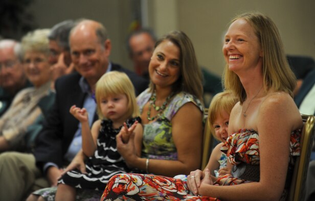 Sarah Dugan laughs as her husband, U.S. Air Force Maj. Patrick Dugan, gives a speech at Moody Air Force Base, Ga., June 28, 2012. During his speech, Dugan thanked his family for their continued support, which helped him achieve the award. (U.S. Air Force photo by Airman 1st Class Douglas Ellis/Released) 
