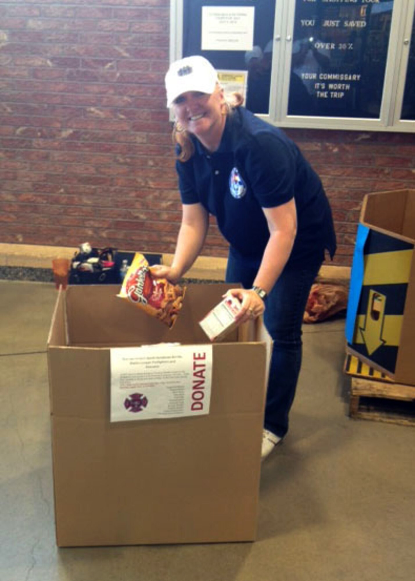 PETERSON AIR FORCE BASE, Colo. – Senior Master Sgt. Lucinda Yslas, Top Three member, collects donations from shoppers at the base Commissary June 28, 2012. The event was sponsored by the Top Three at Peterson AFB, an organization consisting of Airmen from the top three enlisted ranks. Over 2,500 pounds of food were collected by enlisted volunteers for Care and Share to be distributed to firefighters and evacuees of the Waldo Canyon Fire. (Courtesy photo)