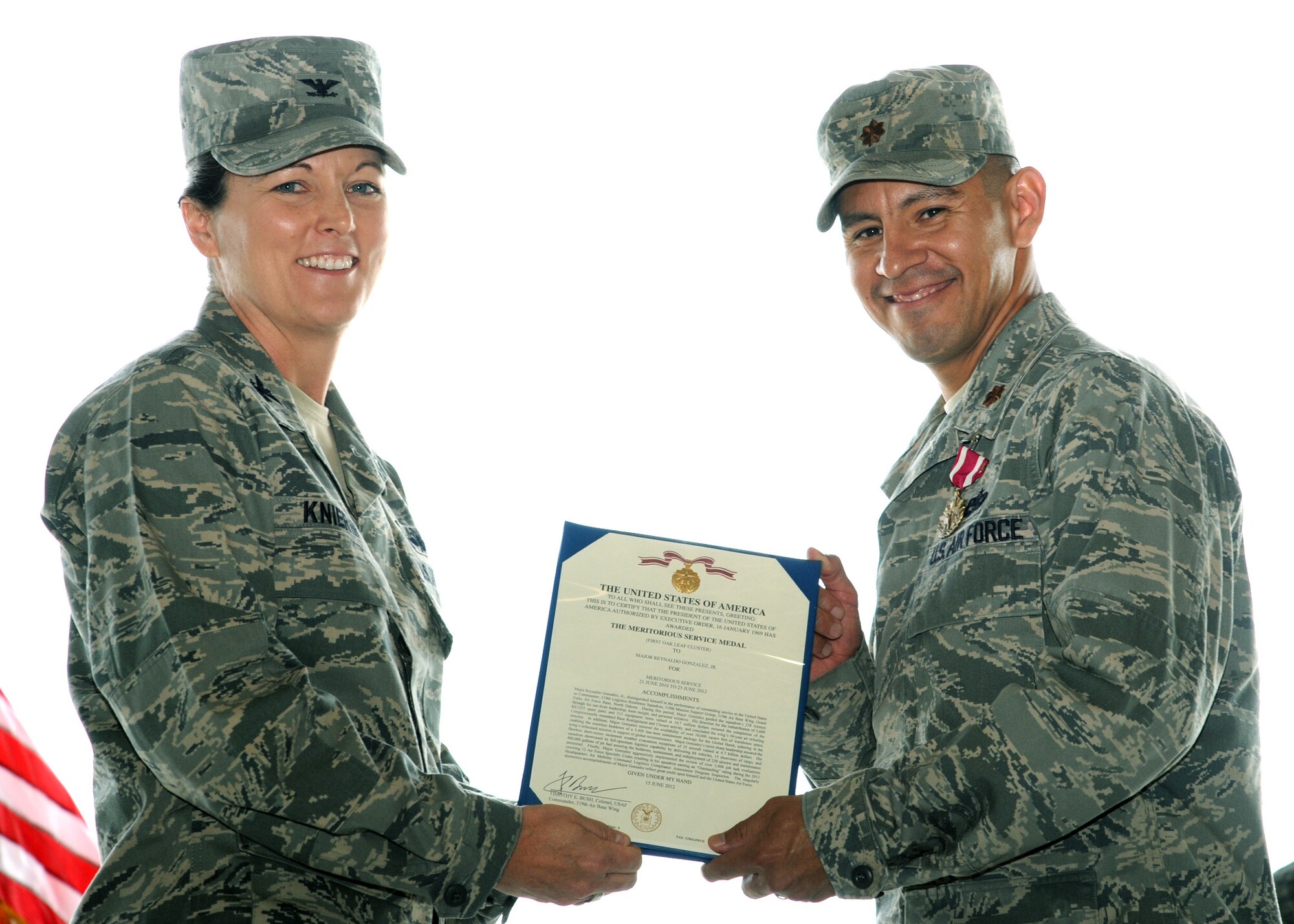 Col. Tammy Knieriem, 319th Mission Support Group commander presents Maj. Reynaldo Gonzalez, 319th Logistics Readiness Squadron commander, with ¬the Meritorious Service medal, June 27, 2012, on Grand Forks Air Force base, N.D.  Renaldo handed over command of the 319th LRS to Maj. Johari Hemphill. (U.S. Air Force photo by Senior Airman Amber Bennett)