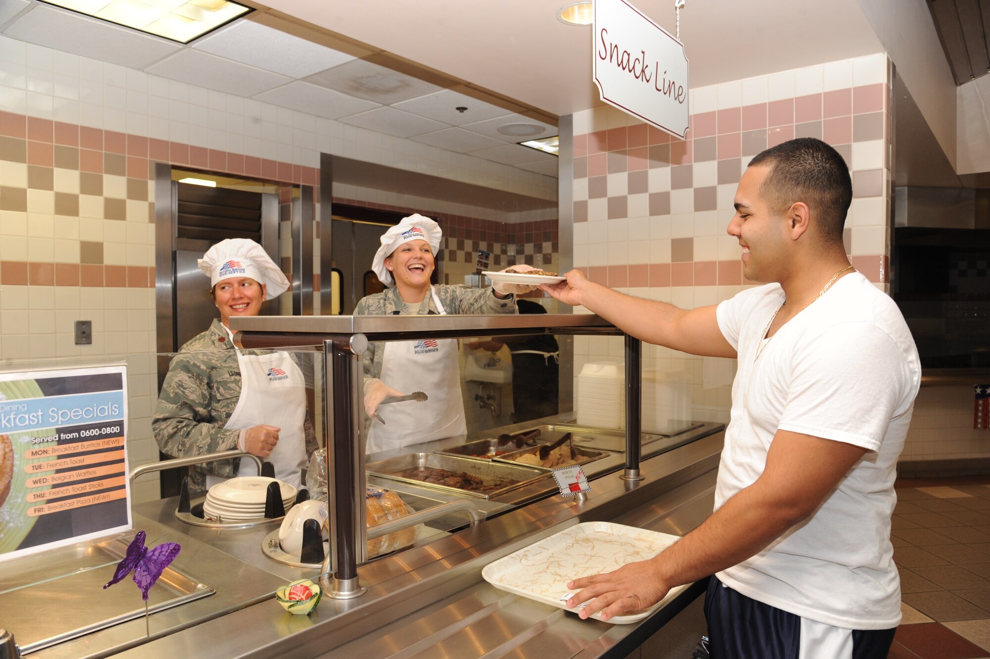 Maj. Wendy Leone, 319th Comptroller Squadron commander, and Staff Sgt. Amanda Grabiec, 319th Air Base Wing, serve food to Airman 1st Class Edwin Nunez Jr., 319th Logistics Readiness Squadron, during an Airmen Appreciation Dinner on June 27, 2012, on Grand Forks Air Force Base, N.D.  The dinner was held at the Airey Dining Facility by 319th Air Base Wing leadership to thank Airmen for all they do. (U.S. Air Force photo by Airman 1st Class Xavier Navarro)