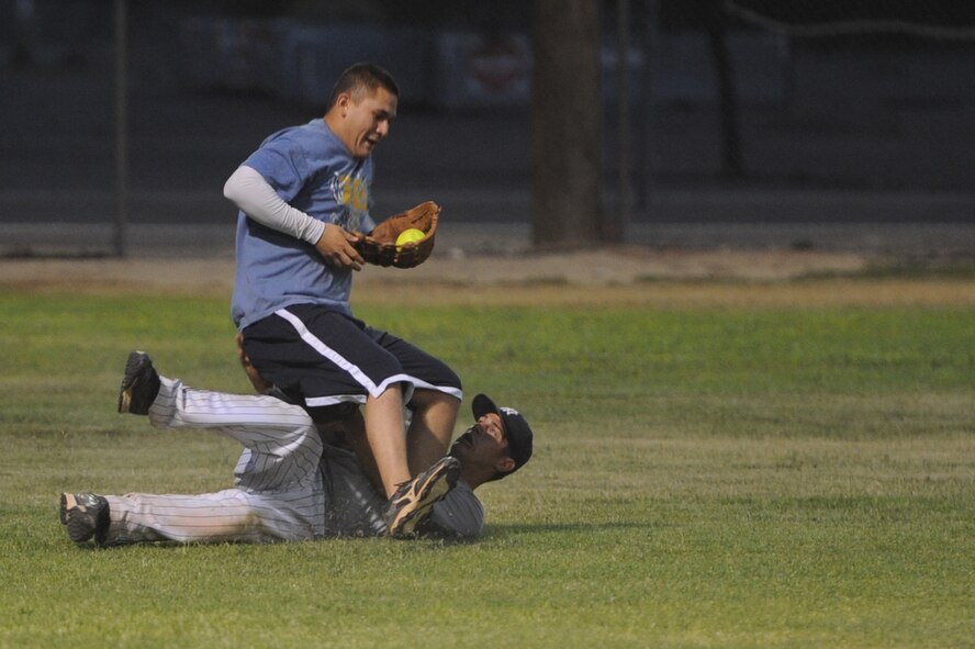 Mario Huerta, 56th Security Forces Squadron, makes a risky catch June 20 and tramples Tyler Rawlings, 56th Fighter Wing Command Post and American League team member, during the softball all-star game at the Luke Air Force Base Bryant Fitness Center softball field. Huerta’s catch was the last out in the 6th inning.  (U.S. Air Force photo by Airman 1st Class Devante Williams)