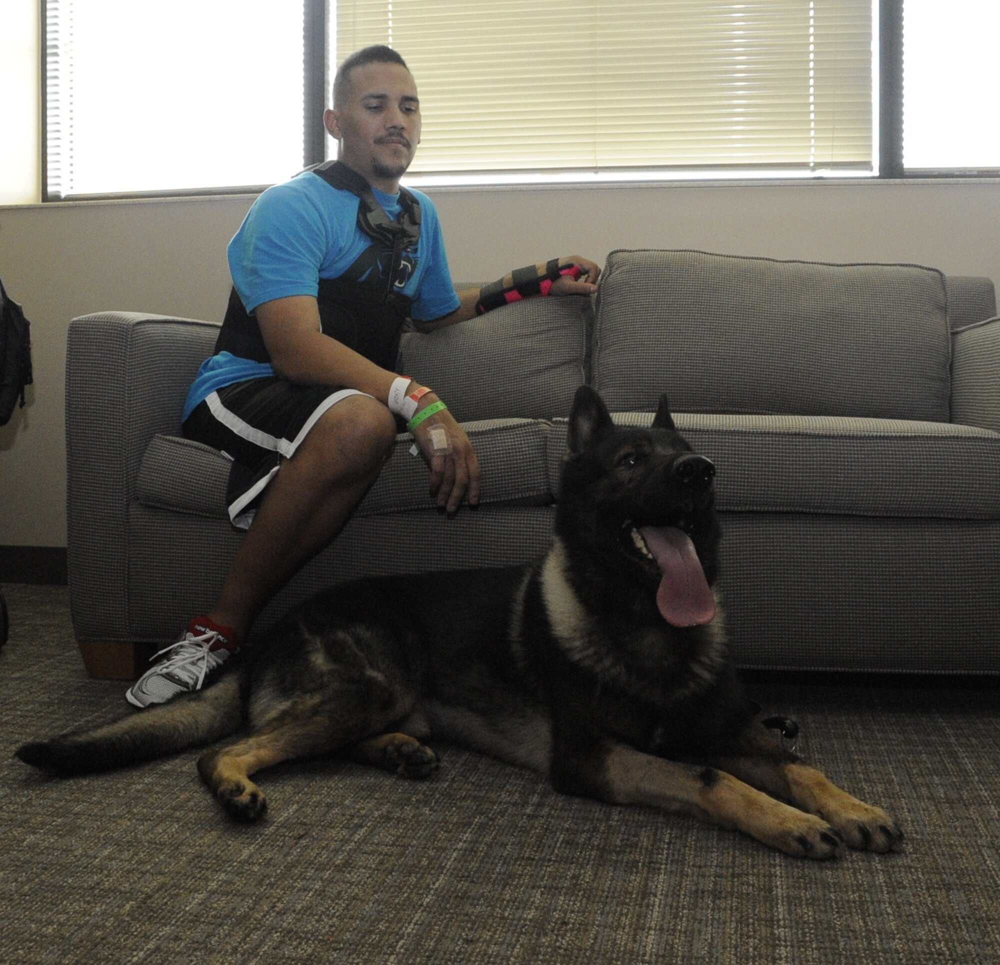 Staff Sgt. Brian Williams watches over his military working dog Carly. Williams and his JB MDL visitors brought Carly to his apartment at the medical center so the two could spend time together. (U.S. Air Force photos by 2nd Lt. Alexis McGee/Released)