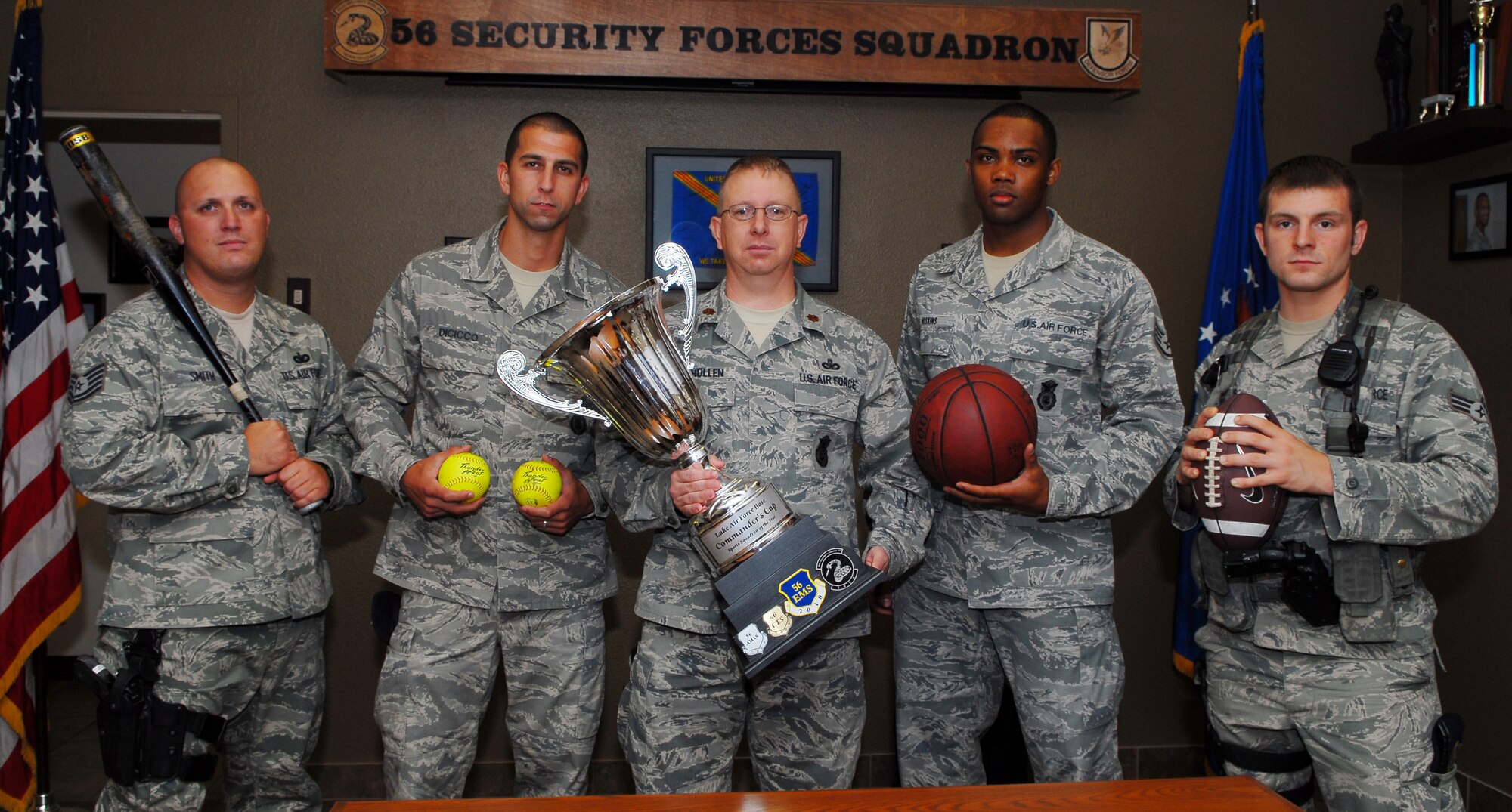 Maj. Gerald Mulhollen, 56th Security Forces Squadron commander, center, holds the commander’s cup as he poses for a picture with four of SFS’s athletes June 18 at building 179.  (U.S. Air Force photo by Airman 1st Class David Owsianka)