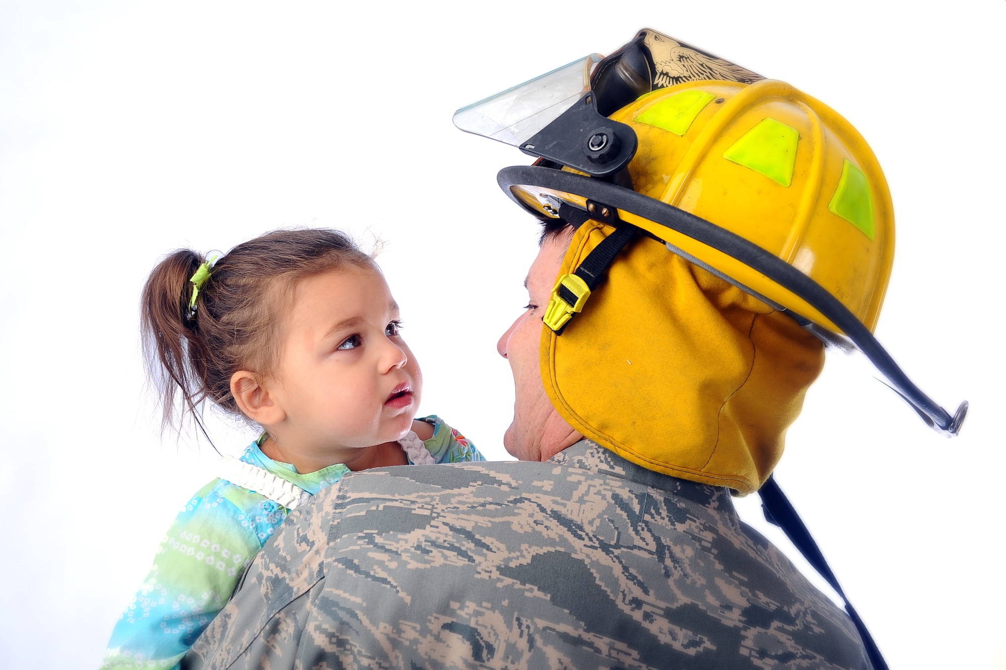 Annabella Krueger, daughter of Chad and Mirela Krueger stares into the face of U.S. Air Force Senior Master Sgt. Gary Self, a 45th Reconnaissance Squadron member and volunteer firefighter with Murray Fire and Rescue in Cass County, Neb. Annabella suffers from tuberous sclerosis complex and Self answered the call one night that saved her life. (U.S. Air Force photo by Josh Plueger/Released)